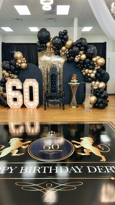 a 50th birthday party with balloons and black and gold decorations on the dancefloor