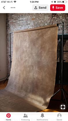 a photo studio with a brown backdrop in front of a brick wall and wooden floor