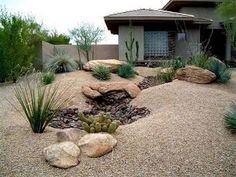 a house with rocks and plants in the front yard