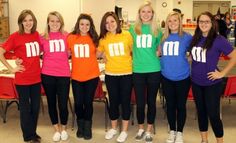 a group of women standing next to each other wearing t - shirts with m on them