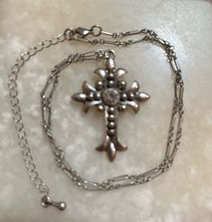 This is a silver-tone cross with a rhinestone in the center. There is no markings as to who made it. The unique-looking chain measures 15" long, plus it has a 3" extension chain. The cross measures 1 3/8" by 1 5/8". In excellent shape. The shipping weight will be 2 ounces. Metal Cross Jewelry With Silver Chain, Silver Chain Cross Metal Jewelry, Silver Chain Metal Cross Jewelry, Metal Cross Jewelry With Adjustable Chain, Metal Cross Necklaces With Silver Chain, Silver Metal Crucifix Necklace, Silver Cross Metal Jewelry, Metal Cross Necklace With Chain, Metal Cross Necklace With Chain Pendant