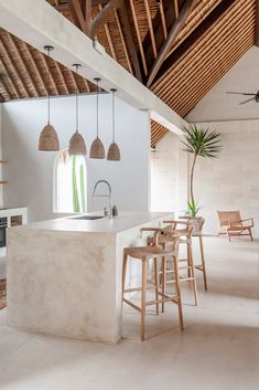 an open kitchen and dining area with white walls, wood ceilinging and exposed beams