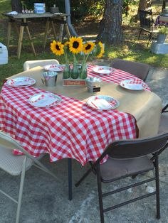 a table set up with plates and flowers in vases on top of the table