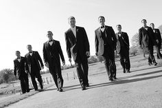 a group of men in suits walking down the street