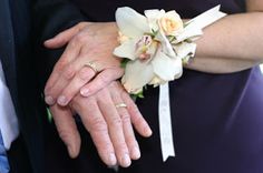 the bride and groom are holding each other's hands with their wedding rings on them