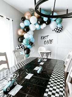 a black and white checkered table with balloons in the shape of race cars on it