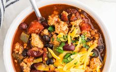 a white bowl filled with chili and chicken soup