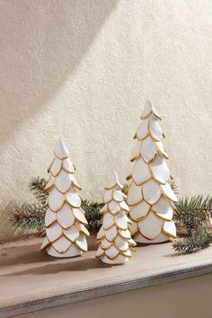 three ceramic christmas trees sitting on top of a table