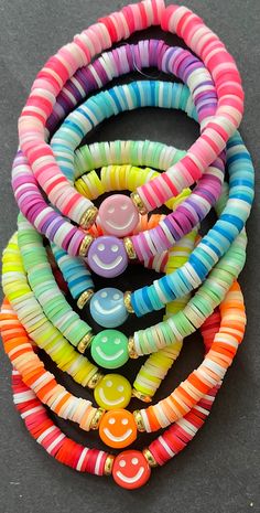 multicolored bracelets with smiley faces and beads on each strand, all stacked together