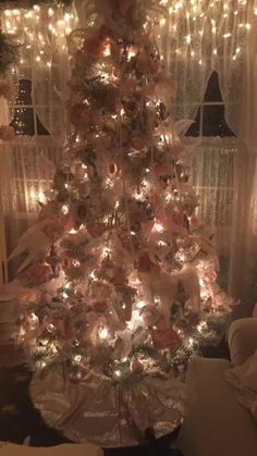 a white christmas tree with pink and gold ornaments