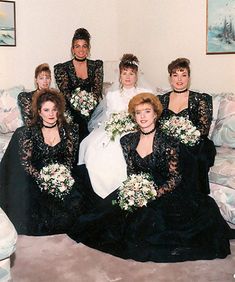 the bridesmaids are posing for a photo in their black dresses and bouquets