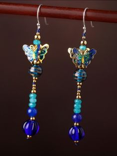 Styled after ancient East Asian queen's and princess's royal jewelries. Colorful butterflies made with Peking's traditional royal handicraft enamel cloisonné, with history of over 600 years, combining metal art and porcelain painting. Decorated with precious blue chalcedony beads.  Extra long, with length of 66 mm (excluding hook).  Surest to catch eyes with its splendid Oriental design.  A wonderful gift or simply a nice treat for yourself. Exclusive at The Butterfly Bay, while stock lasts. Blue Enamel Dangle Jewelry, Hand Painted Dangle Jewelry, Blue Jewelry With Butterfly Charm For Jewelry Making, Traditional Blue Nickel-free Jewelry, Hand Painted Turquoise Elegant Jewelry, Elegant Hand Painted Turquoise Jewelry, Elegant Turquoise Hand Painted Jewelry, Handmade Blue Ornate Earrings, Blue Ornate Handmade Earrings