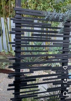 an outdoor sculpture made out of wooden slats with numbers and symbols on it in the middle of a garden