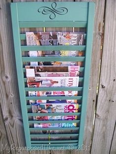 a magazine rack with magazines on it next to a fence