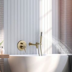 a white bath tub sitting next to a brick wall