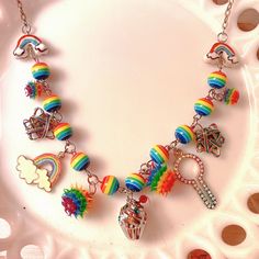 "Beaded chain made with plastic rainbow beads, adorned with upcycled, rescued charms from broken jewelry, all with a \"rainbow\" theme. Perfect for Pride or any rainbow fan! One of a kind piece!! 🌈🏳️🌈 Because of the upcycled nature of the pieces of this necklace, I cannot guarantee that this necklace is 100% allergy free. That being said, all of the findings are nickel free.  Due to the handmade nature of my items, please handle them with care and refrain from getting them wet or pulling/tugging on them." Funky Handmade Rainbow Jewelry, Whimsical Rainbow Dangle Jewelry, Funky Rainbow Jewelry With Colorful Beads, Adjustable Rainbow Beaded Necklace, Playful Rainbow Charm Necklace As Gift, Playful Handmade Rainbow Necklace, Adjustable Rainbow Necklace With Colorful Beads, Playful Rainbow Charm Necklace For Gift, Playful Rainbow Charm Necklaces For Gifts