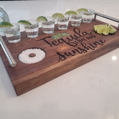 there is a wooden tray with glasses and limes on it that says tequila y'all the sunshine