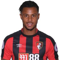 a soccer player poses for a photo in front of a white background wearing a black and red striped shirt