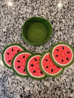 four pieces of watermelon crocheted placemats next to a bowl