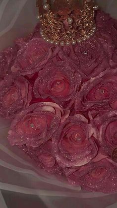 a bouquet of pink roses with a tiara on top