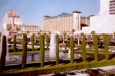 cars are parked on the street in front of hotels and casinos with water spouting from them