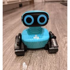 a blue robot sitting on top of a wooden floor