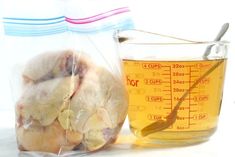 a measuring cup filled with liquid next to a bag of chicken wings and a measuring spoon