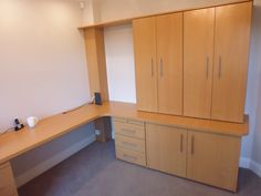 an office desk with drawers and cupboards in the corner