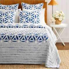 a bed with blue and white bedspread in a bedroom