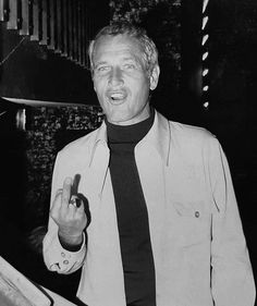 a man in a suit and tie making the peace sign