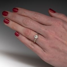 a woman's hand with a ring on it and a diamond in the middle