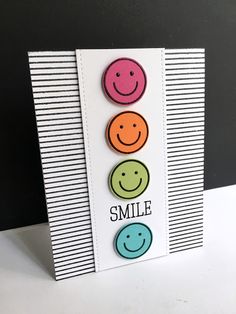 a card with three smiley faces on it and the words smile written in different colors