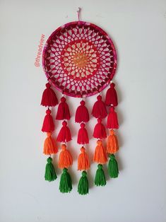 a decorative wall hanging with tassels on it