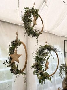 three hanging wreaths with stars and greenery