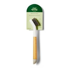 a white and green toothbrush sitting on top of a wooden stick