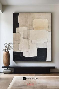 an abstract painting is displayed on the wall in this modern living room with black and white accents