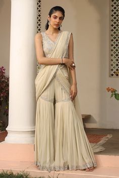 Ivory draped pant saree with sequin, dori embroidery in floral pattern. Paired with sleeveless embroidered blouse. - Aza Fashions Cream Pre-draped Saree With Cutdana For Diwali, Fitted V-neck Saree With Cutdana, Traditional Cream Pre-draped Saree With Cutdana, Bohemian Unstitched Pre-draped Saree With Cutdana, Festive Cream Pre-draped Saree With Cutdana Details, Pant Saree, Dori Embroidery, Saree Gowns, Cotton Sarees Handloom