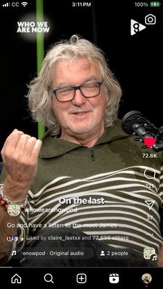 an older man wearing glasses and a green hoodie is holding his hand up to the camera