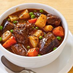 a white bowl filled with stew and vegetables