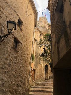 an alley way with stone buildings and steps leading up to the building on one side