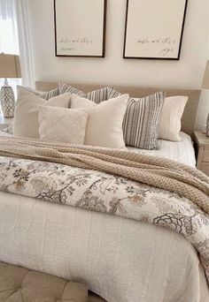 a large bed sitting in a bedroom next to two framed pictures