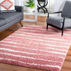 a living room filled with furniture and a pink rug