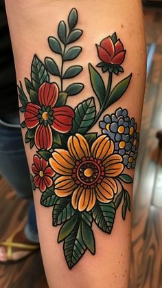 a woman's leg with flowers and leaves on it