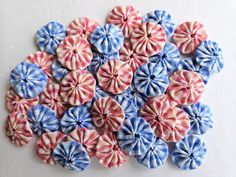 a bunch of small red, white and blue hair bows on a white table top