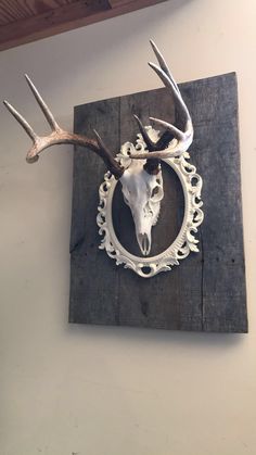 a deer's head mounted to the side of a wall with an ornate frame around it