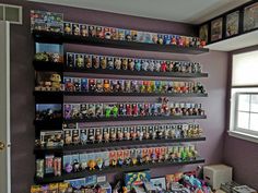 a room filled with lots of toys on shelves next to a wall full of pictures