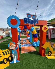 an outdoor area with fake grass, decorations and construction vehicles on the ground for kids to play in