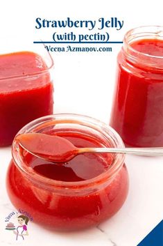 strawberry jelly with pecini in small glass jars and spoon on white marble surface