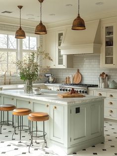 a kitchen with an island and stools in the center, surrounded by white cabinets