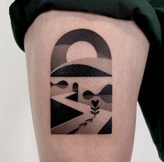 a person with a tattoo on their leg that has an image of a road and trees